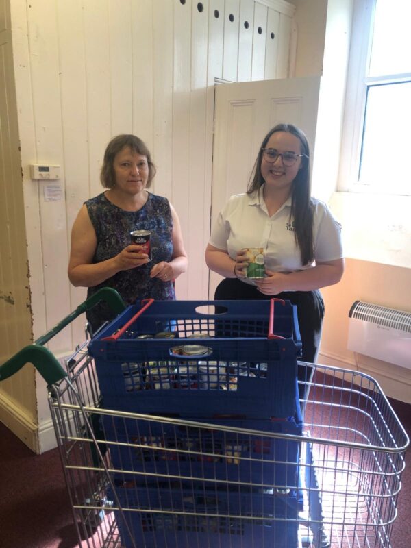 Two staff from Tai Tarian with a food donation